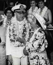Load image into Gallery viewer, Black and white photo of a ship captain with a Hawaiian woman standing together. They are both wearing many flower lei and are surrounded by others also wearing flower lei.