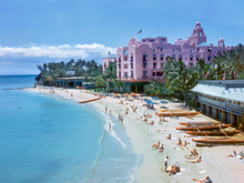 Load image into Gallery viewer, Full color photograph of the pink Royal Hawaiian Hotel and Outrigger Canoe Club on the right and the ocean on the left with Waikiki Beach in the center. Many bathers and outrigger canoes are lined up on the sand..