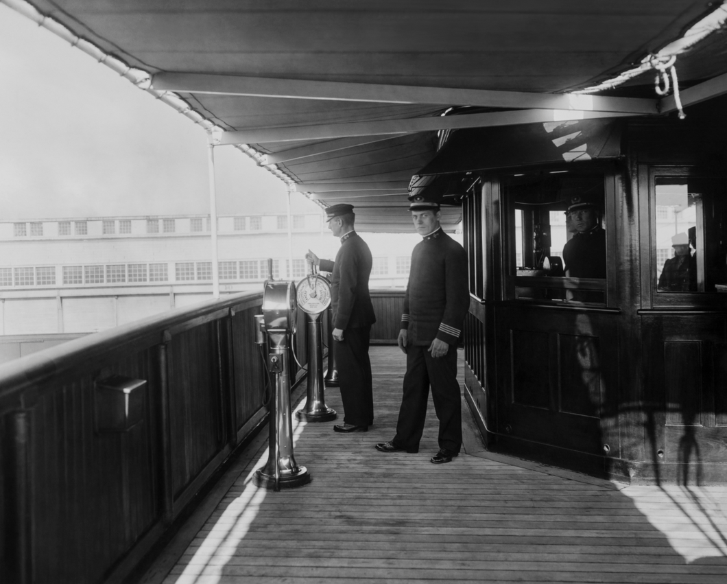Historic black and white photo of the captain and his crew on the bridge of a steamship in the late 1920s.