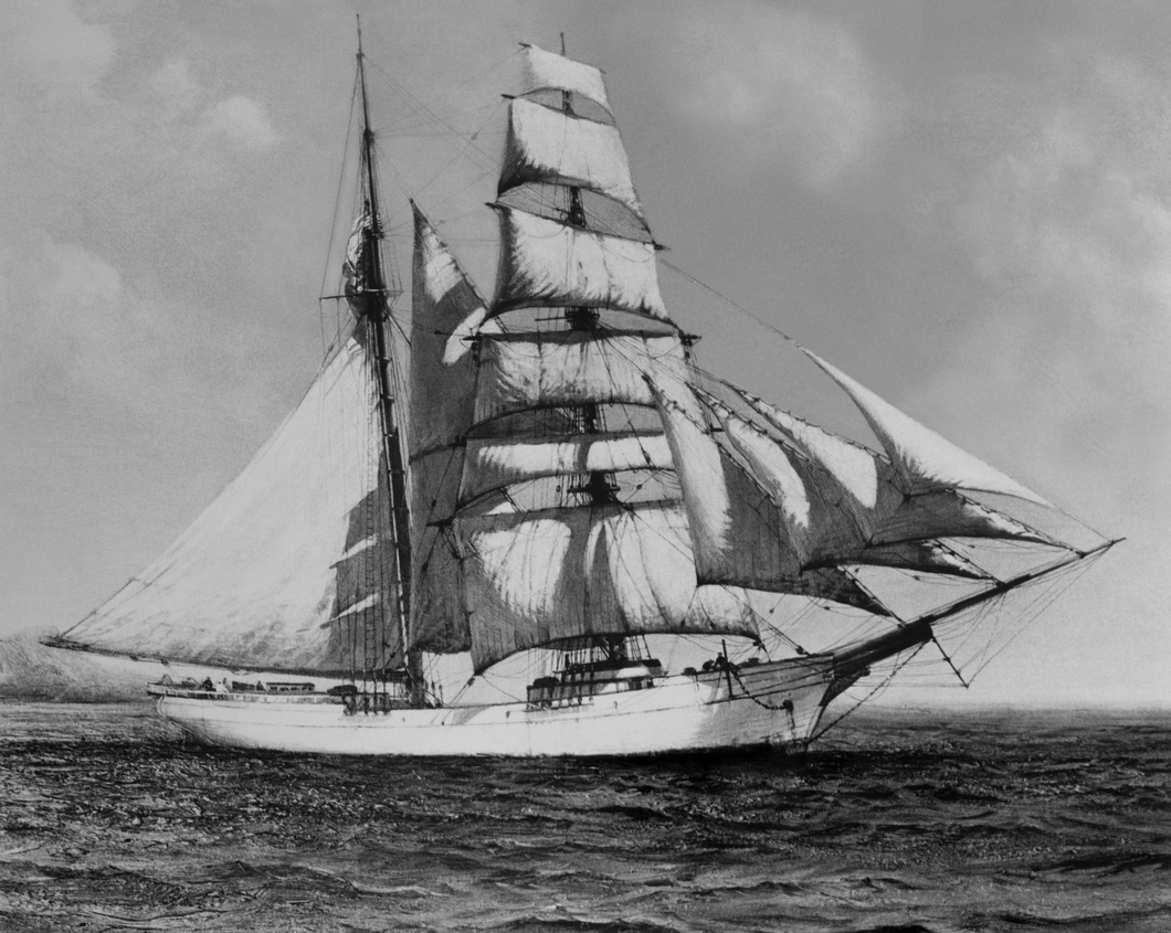 Black and white picture of an old ship with 12 sails on the ocean.