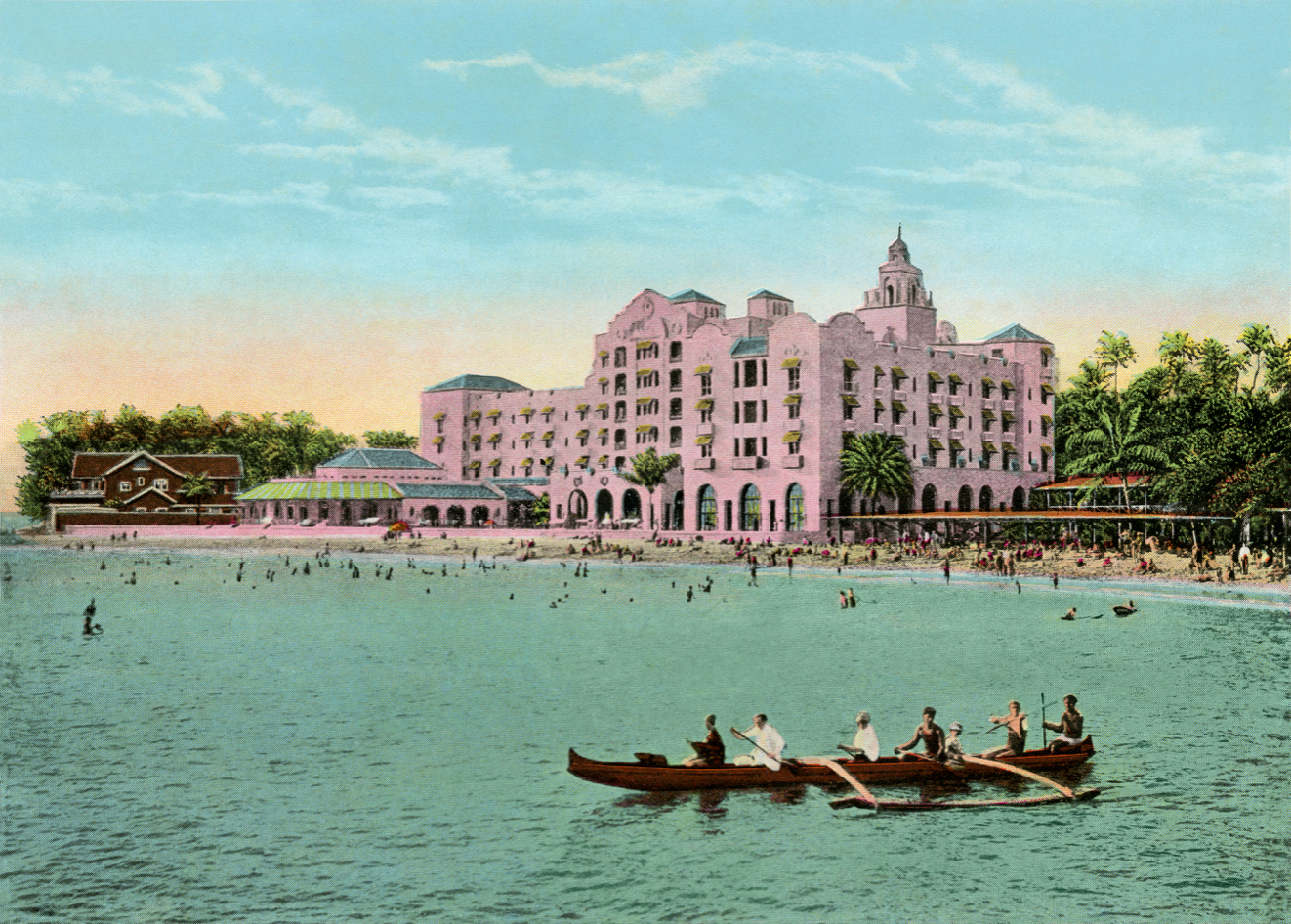 Colorful vintage photograph of the pink Royal Hawaiian Hotel as viewed from the ocean with water and outigger canoe with paddlers in foreground and the beach and hotel in the back.