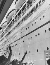 Load image into Gallery viewer, Black and white photo of the side of a ship with people below and streamers flowing from the ship.