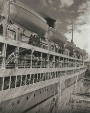Load image into Gallery viewer, Black and white photograph of a large passenger cruise ship with many people visible on the decks and lifeboats, photographed from an angled side view.