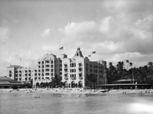 Load image into Gallery viewer, Black and white photograph of the Royal Hawaiian Hotel with Waikiki beach in front of it.