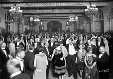Load image into Gallery viewer, Black and white photograph of a festive crowd in a ballroom celebrating the opening of the Royal Hawaiian Hotel,  dressed in 1920s evening wear.